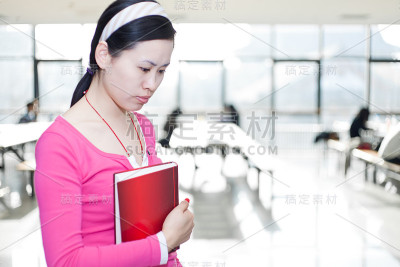 东亚大学生拿着她的书
