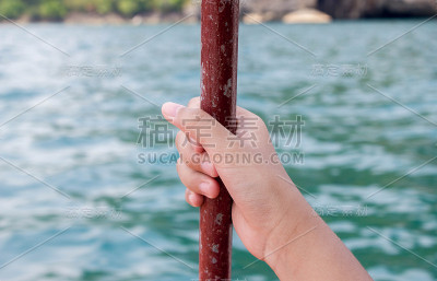 手握杆在海上的船