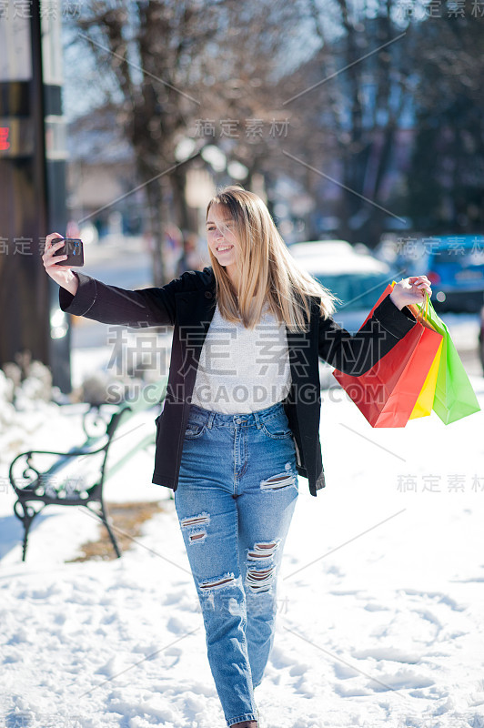 年轻女孩在冬季购物与彩色包