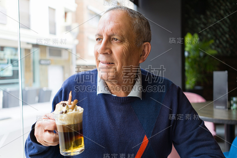 帅气的中年老人在餐厅喝咖啡，微笑着享受幸福和轻松的退休生活