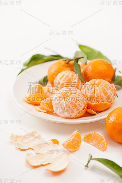 将橘子去皮，在白底上剥去叶子
