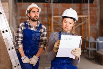 女工头检查建筑工人的工作