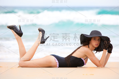 穿着黑色泳衣的女人躺在沙滩上