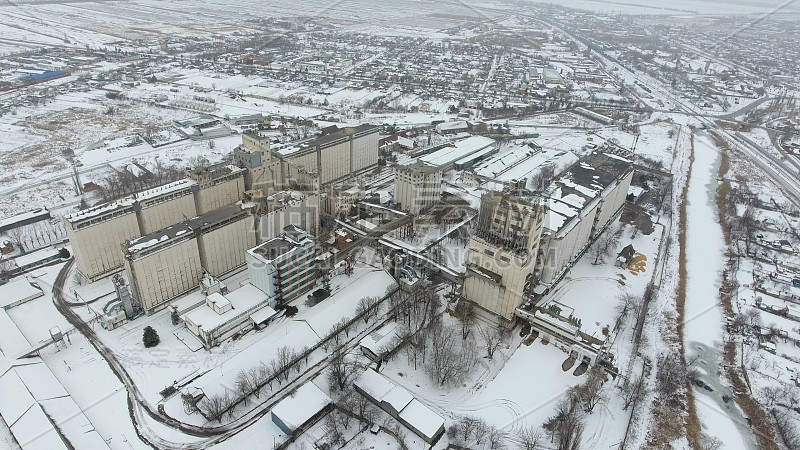 谷物在冬季终了。农村地区被雪覆盖的粮食升降机。干燥和储存谷物的建筑物。