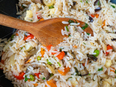 俯视图上木勺插在白米饭里煮蔬菜。