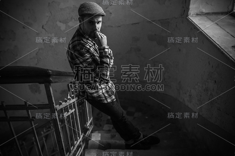 自信的男人摆姿势在边牛仔裤