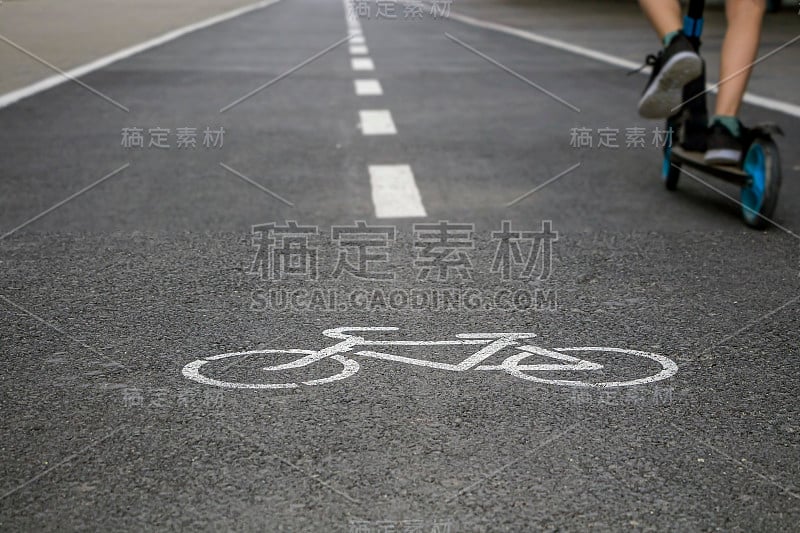 自行车的道路。自行车交通基础设施。白色自行车道标志在沥青路面，安全区域。儿童骑踏板车，遵守道路规则。