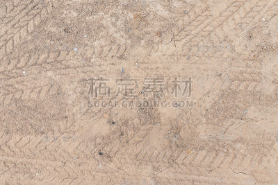 汽车车轮上的土路上有褐色的干土质地面背景。