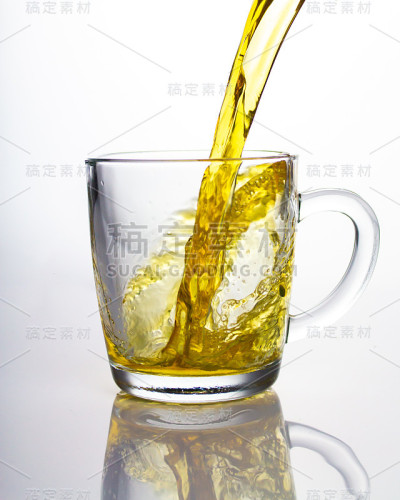 一股黄澄澄的绿茶流进透明的玻璃杯中，美丽的浪花飞舞反射。倒茶