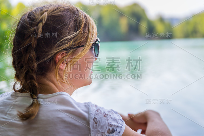 年轻的女孩正在湖上享受她的夏日时光