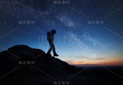太空旅行者在星空下走下岩石山。