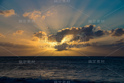 在佛得角的波阿维斯塔，透过大西洋上空的低云在日落的光束
