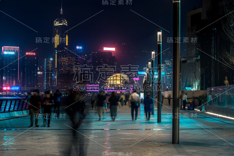 香港城市夜景。在海滨散步的游客