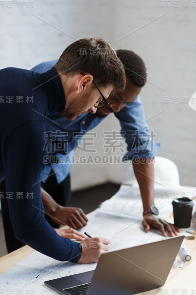 多种族工程师团队在办公室工作，绘制图纸和建筑设备草图，讨论和规划建设项目。合作伙伴在工作中发生争执。