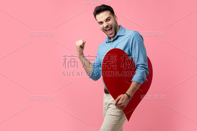 快乐的年轻人捧着大大的红心庆祝