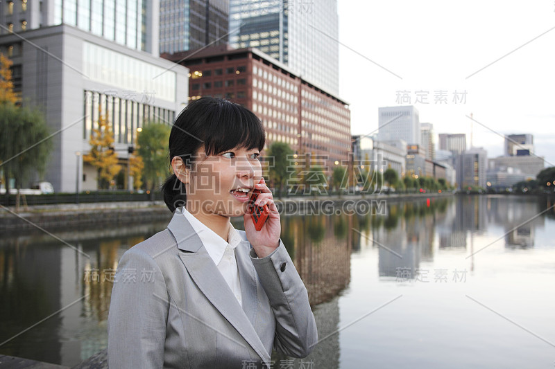 女商人在河边打手机日本人