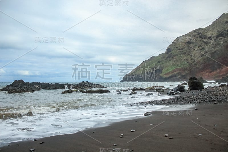 陡峭的熔岩峭壁。蓝色的大海地平线，自然的天空背景。