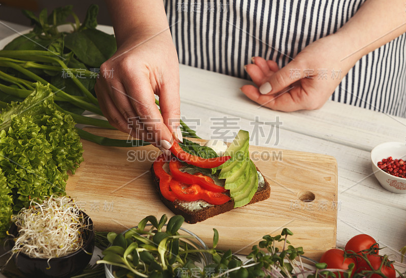 女人正在做美味的烤面包作为健康的零食，特写