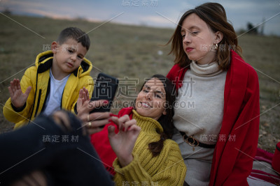 一个女人看着她的手机，使她的家人不安的股票照片