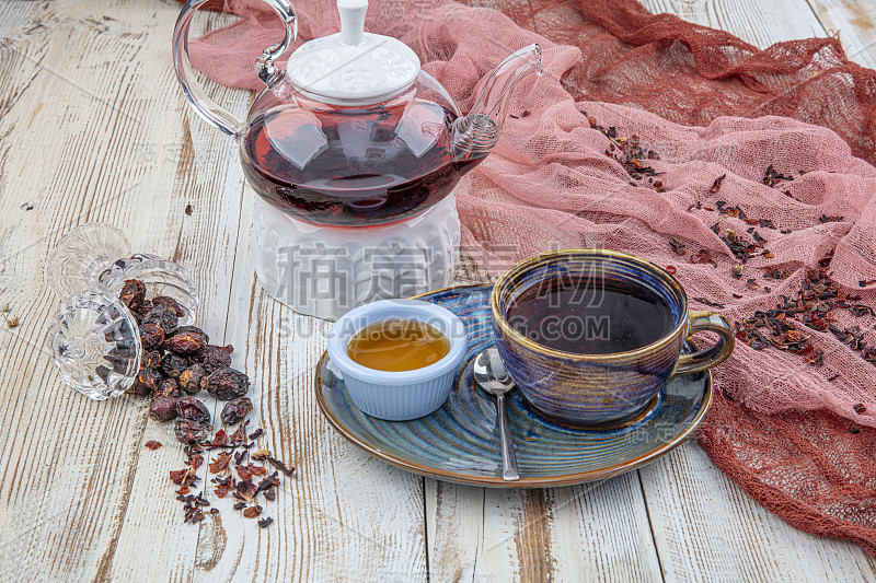 玫瑰果茶:泡茶过程，茶道，一杯新鲜的玫瑰果茶在一个木制的背景。