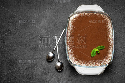 传统的意大利提拉米苏甜点在玻璃烤盘在混凝土背景