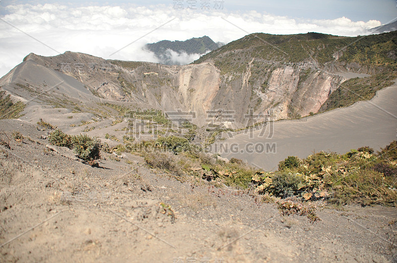 哥斯达黎加的伊拉祖火山。有防护屏障的云层中的火山口。熔岩和浮石的碎片。