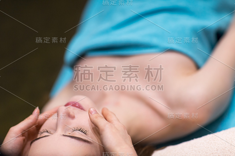 年轻美丽的女人和面部按摩水疗