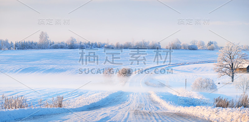 冬季日落时，雾气笼罩着一条被雪覆盖的乡村公路