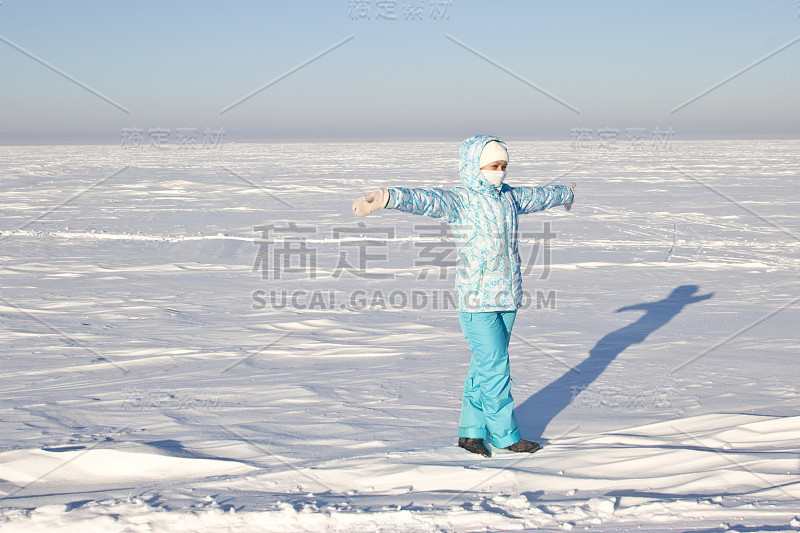 明亮有霜的冬日。冰冻的河流伏尔加。一个女人站在结冰的河边。