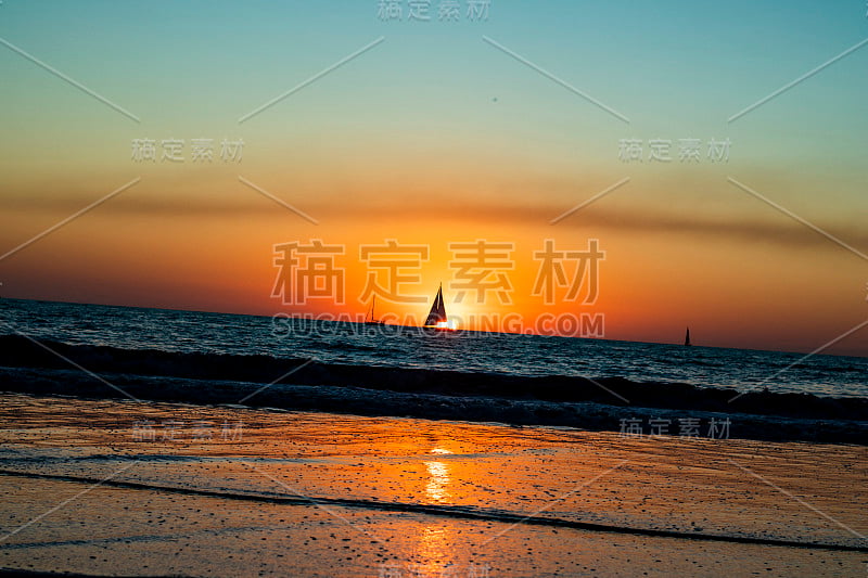 帆船在太平洋上橙色的加州日落，海浪和加州日落，水平图像