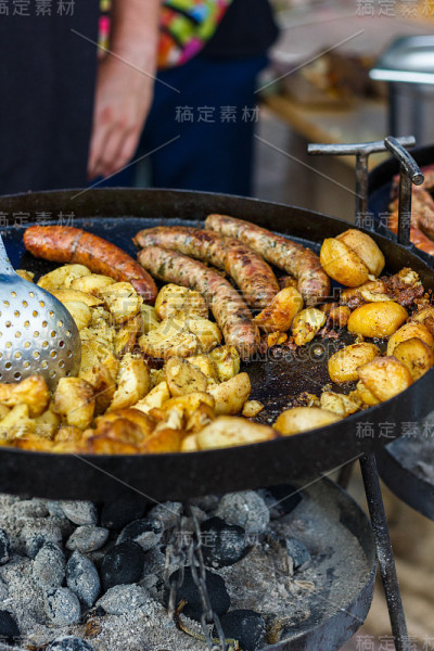 厨师在街头美食节上烹饪土豆和香肠