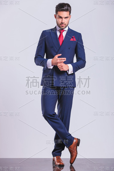 穿着西装，双腿交叉，双手相碰的帅哥