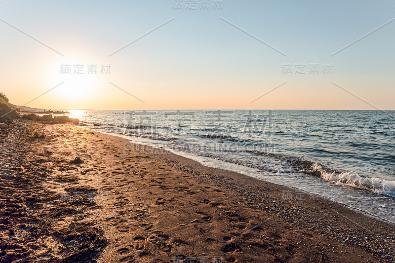 空旷的沙滩上有脚印。夕阳西下的黄昏海景。Peresyp度假村，克拉斯诺达尔地区，俄罗斯。