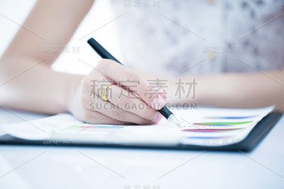 女人手里拿着笔和商业报告。会计