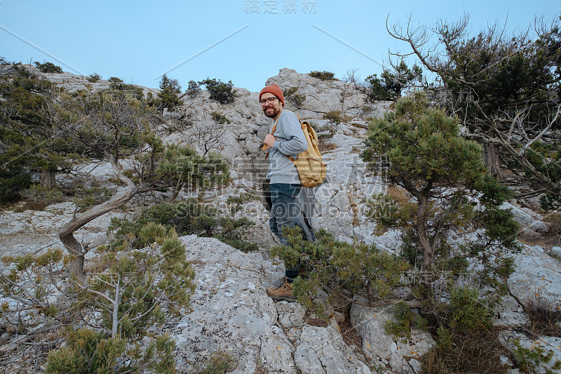 男人背包徒步旅行和红帽子在山区