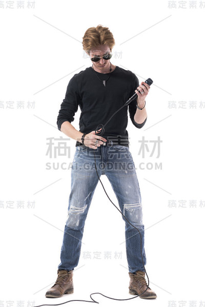 年轻的摇滚男歌手正准备着，看着麦克风