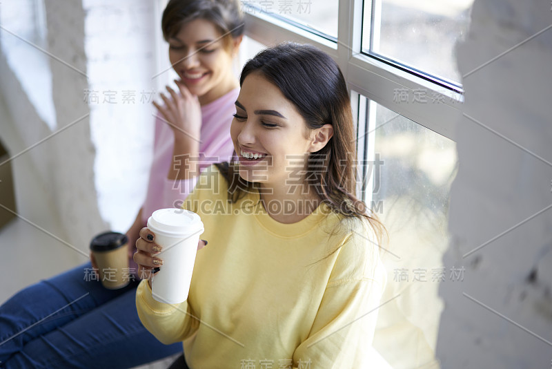 两个快乐的女性最好的朋友享受交流在咖啡休息时间谈论项目的计划，时尚休闲的时髦女孩开玩笑，并有乐趣坐在