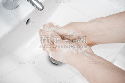 一名男子在水龙头下用自来水深深的洗手。洗手对于避免冠状病毒和细菌感染非常重要。