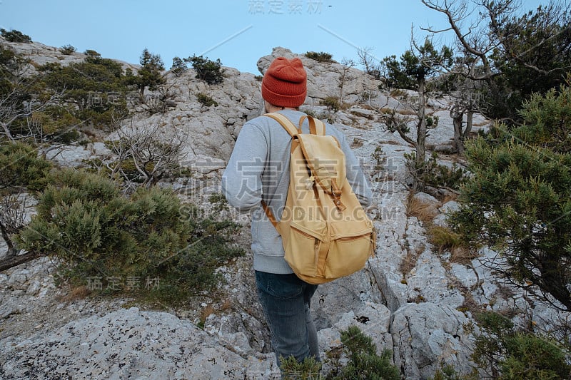 男人背包徒步旅行和红帽子在山区