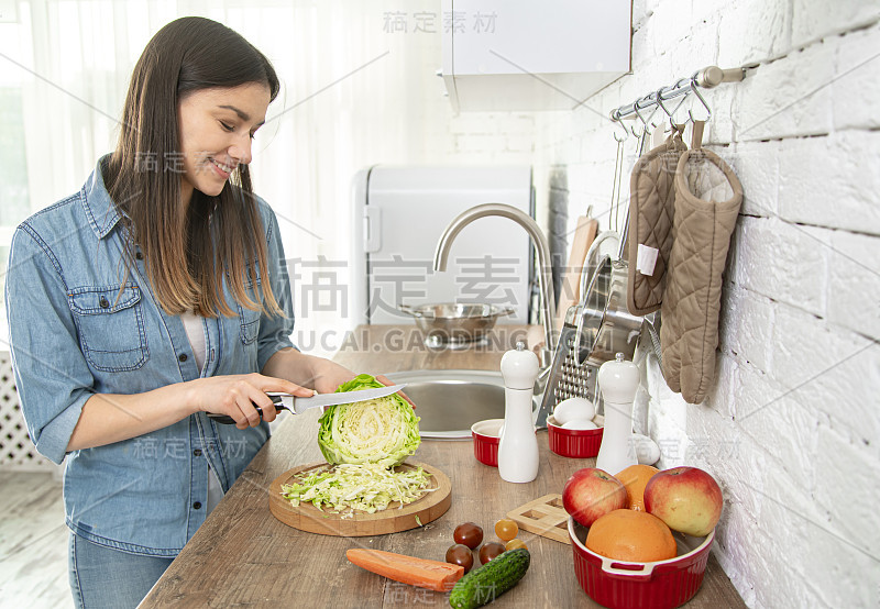 一位年轻妇女正在厨房里准备沙拉。