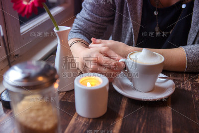 女人坐在咖啡馆里喝咖啡的特写