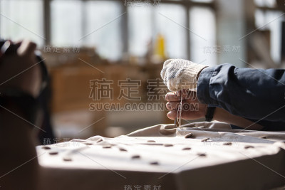 工人的双手制作家具。在沙发上做一辆马车。