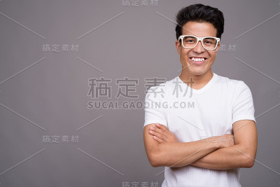 一名年轻的亚洲男子穿着白色衬衫，背景是灰色