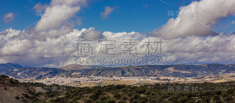 山景上的蓝色多云的天空背景。风景如画的群山在阳光下闪闪发光。令人屏息的自然影像