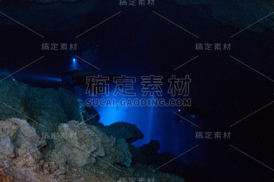 在岩石后面的光线中观察潜水员