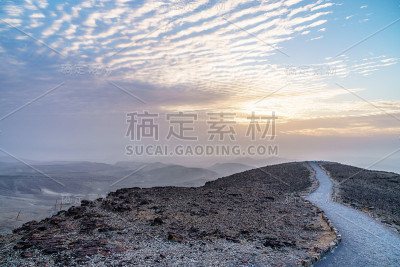 丰富多彩的景观在朱迪安沙漠土地与魔法天空的背景和彩色云彩