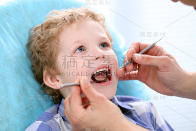男孩有他的牙齿检查由牙医的特写