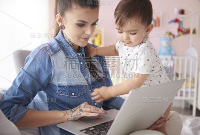 妈妈抱着小男孩用手提电脑