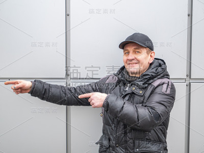 一个男人在街上用手指着方向。