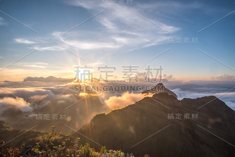 梦幻般的日出在岩石山顶上，看到雾气蒙蒙的山谷。山景城。多雾的山。梦幻福勒斯特。日出云。森林山。秋天的